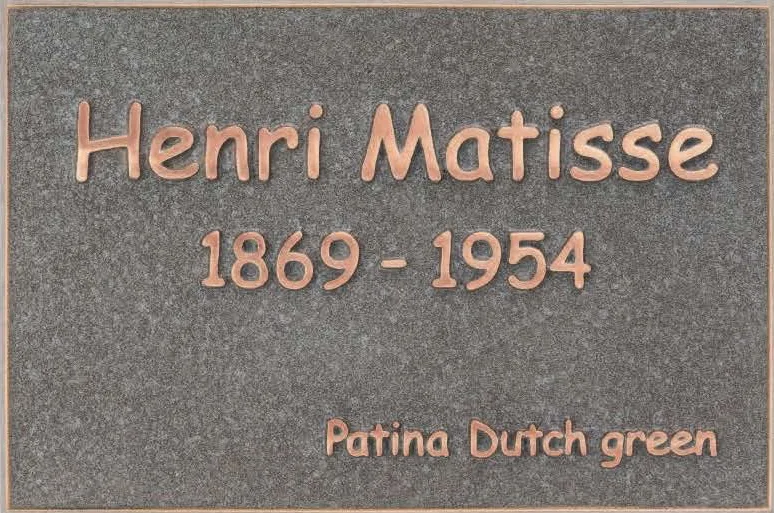Bronzen plaatjes urn muur